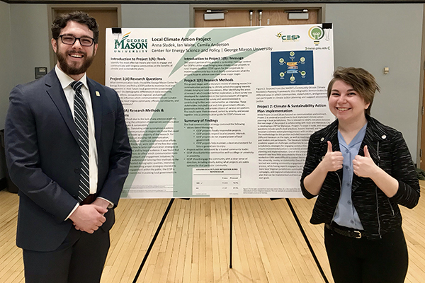 Ian Waite, left, and Anna Sladek pose with their poster depicting their work, with Camila Anderson, on the Local Climate Action Project.