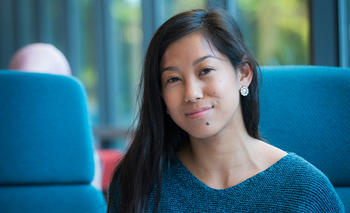 A student in a blue shirt smiles for the camera